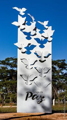 a large white sign with birds flying around it