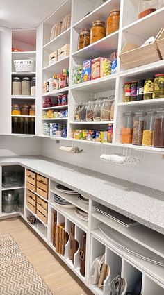 an organized pantry with white cabinets and drawers