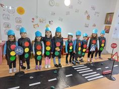 a group of children standing next to each other in front of a traffic light display