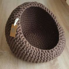 a brown knitted basket with a tag on it