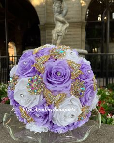 purple and white bridal bouquet in front of a statue