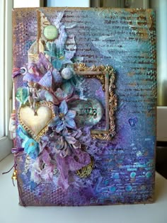 an altered photo frame with flowers and hearts on it's side, in front of a window