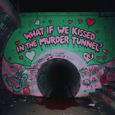 graffiti on the side of a tunnel with words written in pink, green and black