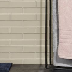 a towel rack next to a white brick wall