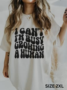 a woman wearing a t - shirt that says i can't busy growing a human