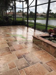 an outdoor patio with stone steps and water feature in the center, surrounded by large windows