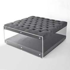 an ottoman that is made out of metal and glass, with buttons on the top