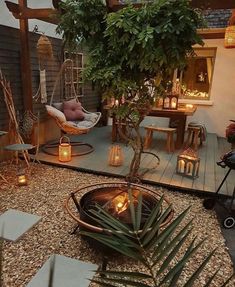 a patio with a tree, hammock chair and lights on the ground next to it