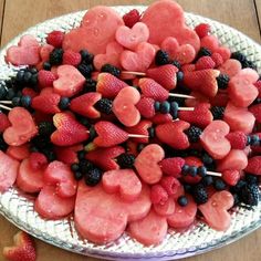 a platter filled with heart shaped fruit on skewered toothpicks and strawberries