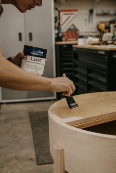 a man sanding down a wooden table with a paintbrush and glue on it