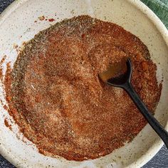 a white bowl filled with spices on top of a table