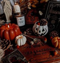 pumpkins, candles and other halloween decorations are on display in front of an old book