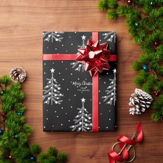 a present wrapped in green and red paper with a bow on it next to christmas decorations