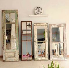 three mirrors sitting next to each other in front of a white wall with a clock on it