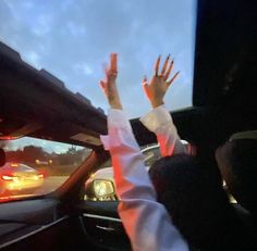 two people in a car with their hands up