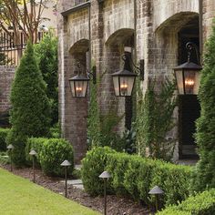 a row of lights in front of a brick building with ivy growing on the walls