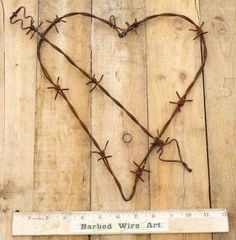 barbed wire heart on wooden planks with ruler