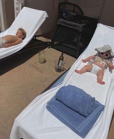 two little kids laying on towels in the sun