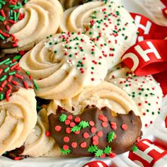 a plate full of decorated cookies and pretzels on top of each other with ribbons around them