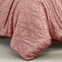 the comforter is made up in pink and has an intricate design on it's side