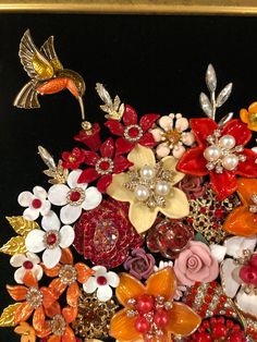 a bunch of flowers that are sitting on a table with brooches and pearls