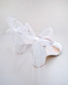 a white shoe with a bow on it