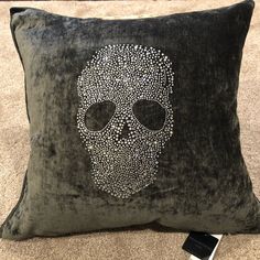 a pillow with a skull on it sitting on the floor next to a cell phone