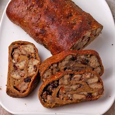 a white plate topped with meat loafs on top of a wooden table next to a knife