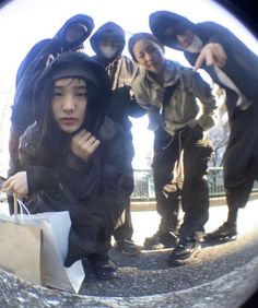 a group of people standing next to each other holding shopping bags