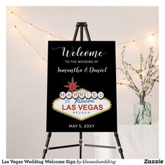 an easel with a welcome sign on it in front of a string of lights