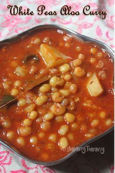 a bowl filled with beans and potatoes on top of a table