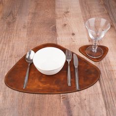 a place setting on a wooden table with silverware