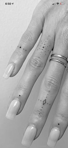 a woman's hand with two rings on it and one ring is in the middle of her finger