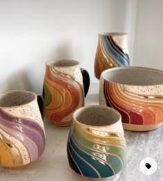 five different colored bowls sitting on top of a white counter next to each other,