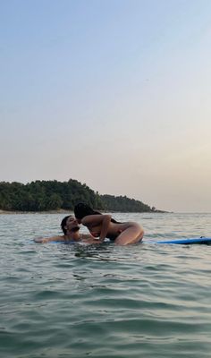 two people are in the water on surfboards