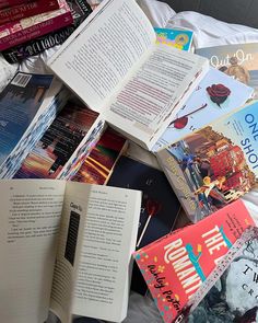 a pile of books sitting on top of a bed