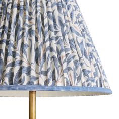 a lamp shade with blue and white leaves on the lampshade, against a white background