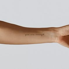 a person's arm with a small tattoo saying you are capable on the wrist