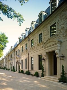 a row of stone buildings with trees in the foreground