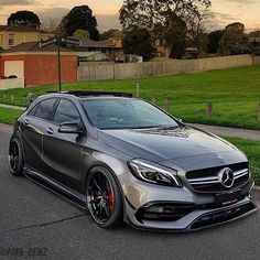 the mercedes cla is parked on the side of the road in front of some houses