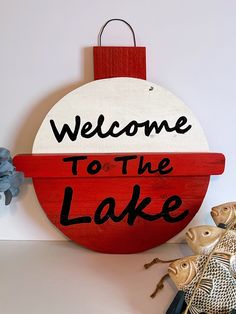 a red and white sign that says welcome to the lake