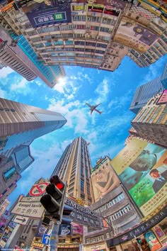 an airplane is flying through the sky above some tall buildings