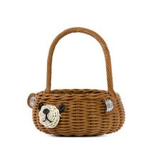 a brown basket with a teddy bear on the front and side, hanging from it's handle