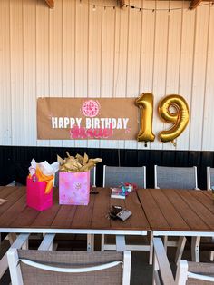 a birthday party with balloons and presents on the table in front of a sign that says happy birthday 19