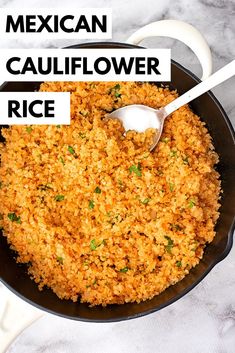 mexican cauliflower rice in a black skillet with a spoon on the side