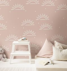 a child's bedroom with pink wallpaper and sun stencils