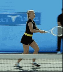 a woman holding a tennis racquet on top of a hard surface tennis court