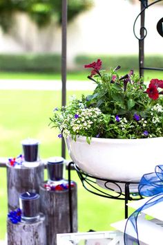 a potted plant on top of a metal stand with flowers in it and blue ribbon