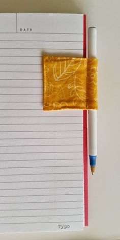 a notepad with a pen on top of it next to a piece of paper