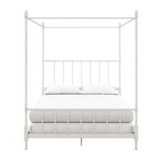 a white bed frame with four posts and pillows